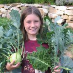 kind met groente in haar handen